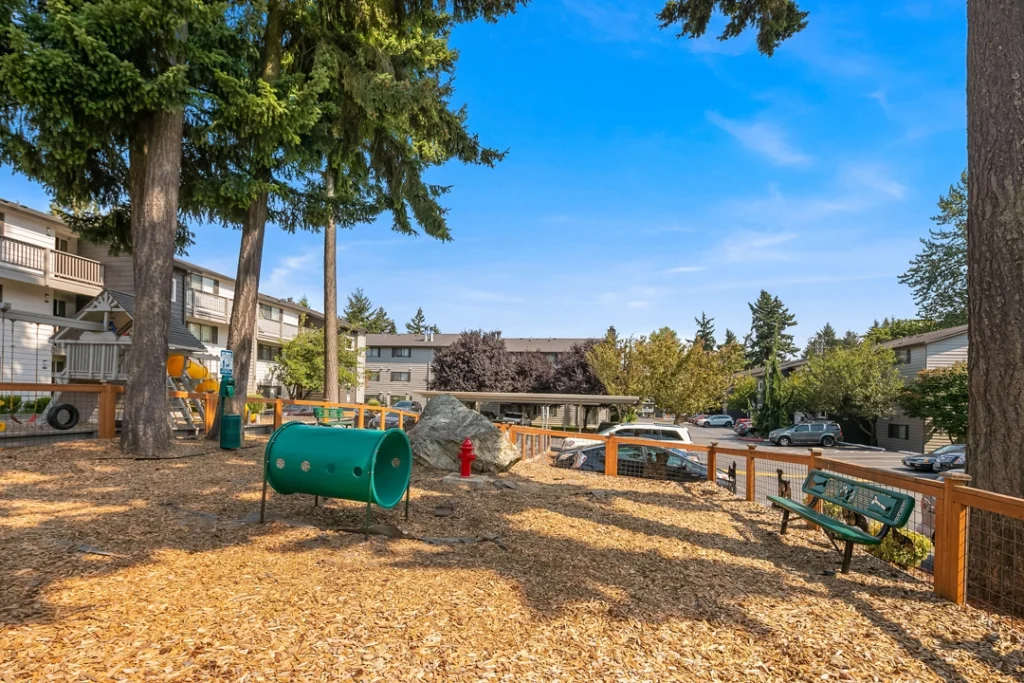 Fenced dog park with agility obstacles and waste station