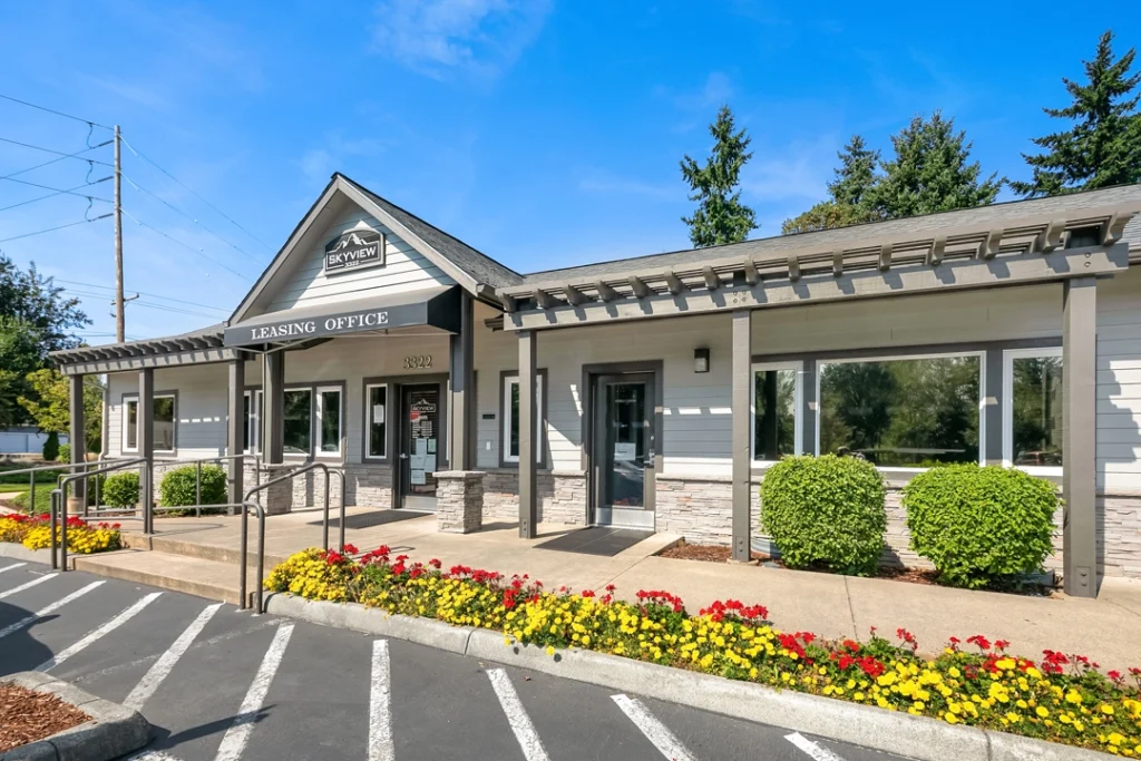 Leasing office exterior with flowers and shrubs